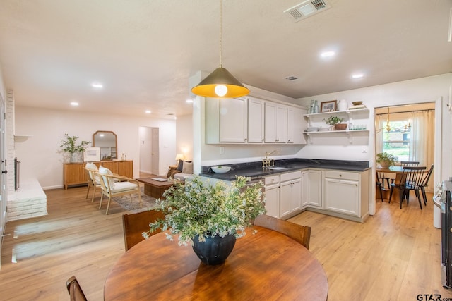 dining space with sink and light hardwood / wood-style floors