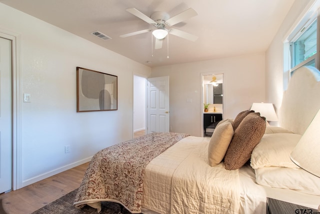 bedroom featuring hardwood / wood-style floors, ceiling fan, and ensuite bathroom