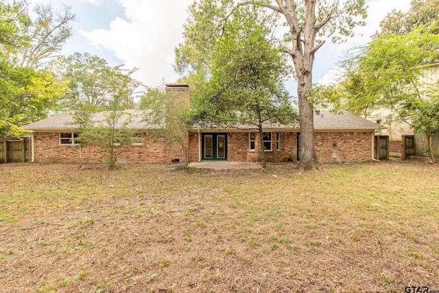 rear view of house featuring a patio area and a yard