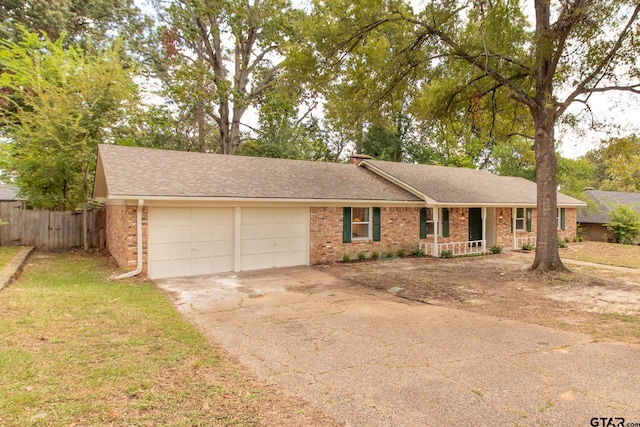 single story home with a porch, a garage, and a front yard