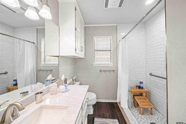 full bathroom featuring visible vents, wood finished floors, vanity, and a tile shower