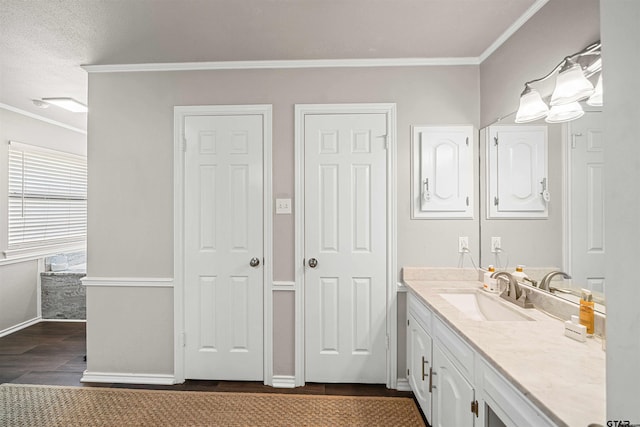 bathroom with vanity, wood finished floors, baseboards, and ornamental molding