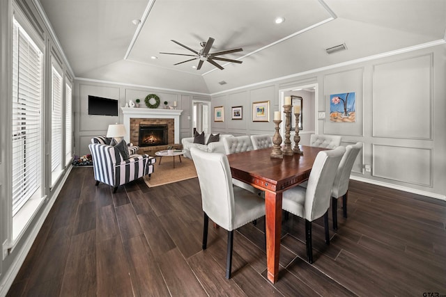 dining room with visible vents, a ceiling fan, dark wood-style floors, a decorative wall, and lofted ceiling