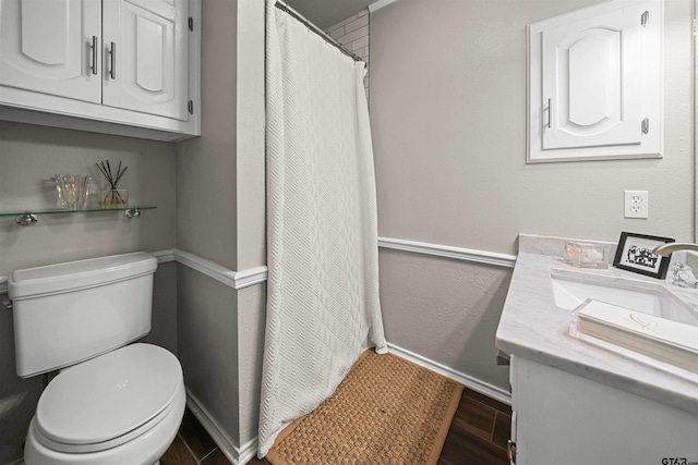 full bathroom featuring curtained shower, baseboards, toilet, wood finished floors, and vanity