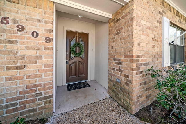 view of exterior entry with brick siding