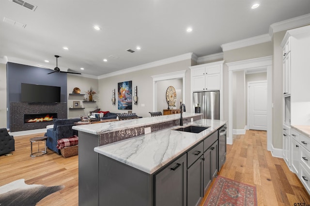 kitchen featuring sink, white cabinetry, a center island with sink, appliances with stainless steel finishes, and gray cabinets