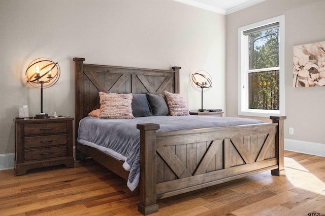 bedroom with wood-type flooring and ornamental molding