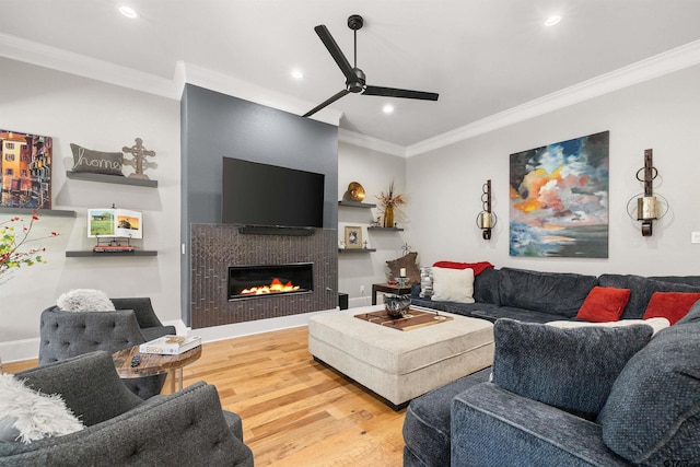 living room featuring wood-type flooring, ornamental molding, and ceiling fan