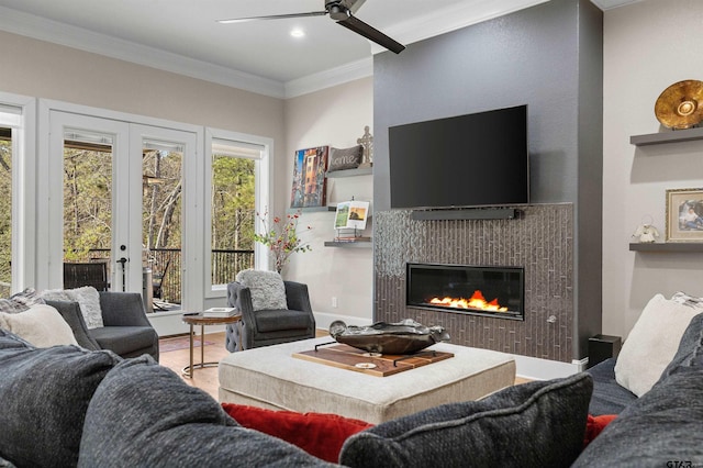 living room with ornamental molding, wood-type flooring, ceiling fan, and french doors