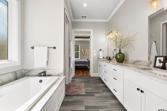 bathroom with ornamental molding, a bathing tub, wood-type flooring, and vanity