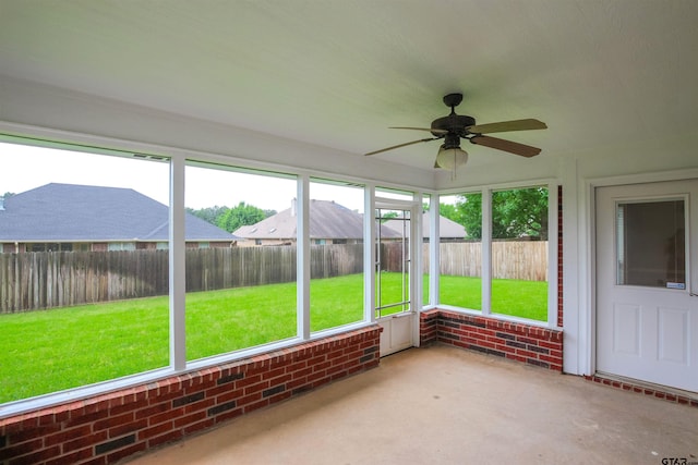 unfurnished sunroom with a ceiling fan