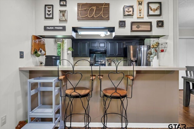 412 Peach Tree Dr, Palestine, TX 75803 - kitchen with stainless steel fridge, a kitchen bar, and blue cabinets