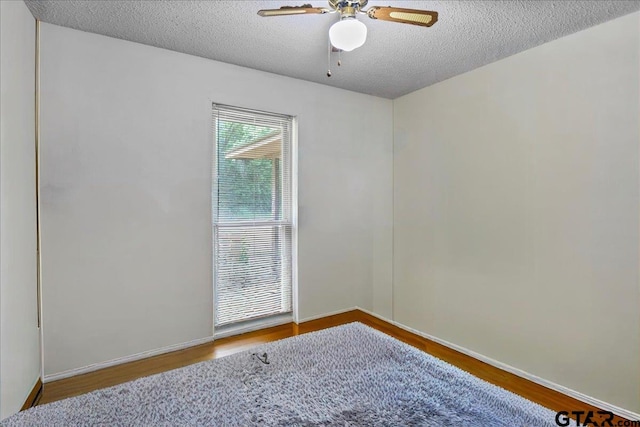 412 Peach Tree Dr, Palestine, TX 75803 - spare room featuring wood finished floors, a textured ceiling, and a ceiling fan