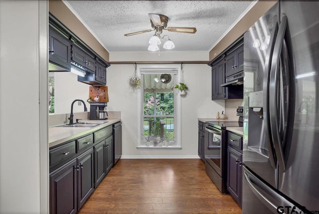 412 Peach Tree Dr, Palestine, TX 75803 - kitchen featuring stainless steel appliances, light countertops, a textured ceiling, dark wood finished floors, and under cabinet range hood