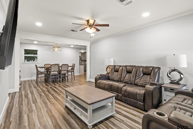 living room with hardwood / wood-style flooring, ornamental molding, and ceiling fan