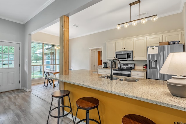 14677 County Road 2337, Tyler, TX 75707 - kitchen featuring stainless steel appliances, a sink, a kitchen breakfast bar, crown molding, and light stone countertops