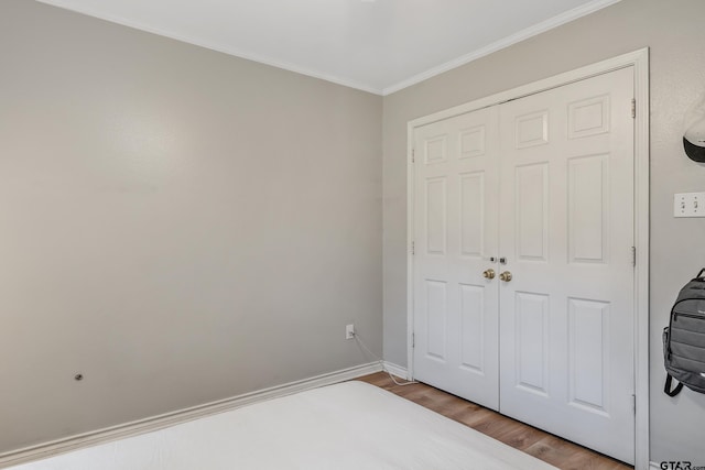 14677 County Road 2337, Tyler, TX 75707 - unfurnished bedroom with wood finished floors, ornamental molding, baseboards, and a closet