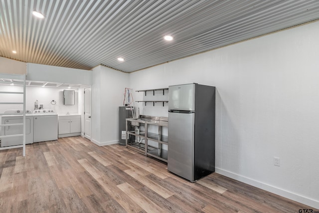 14677 County Road 2337, Tyler, TX 75707 - kitchen featuring freestanding refrigerator, washing machine and dryer, electric water heater, light wood finished floors, and baseboards