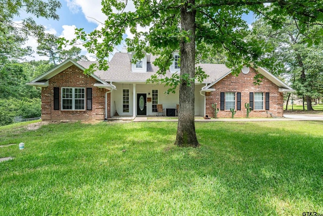 14677 County Road 2337, Tyler, TX 75707 - view of front of home with a front lawn, a shingled roof, and brick siding