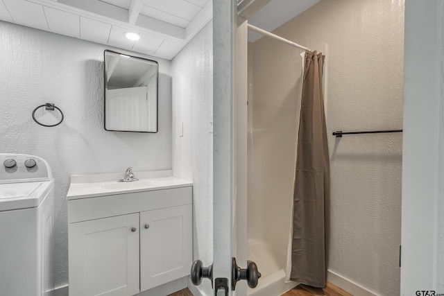 14677 County Road 2337, Tyler, TX 75707 - bathroom with washer / clothes dryer, a stall shower, vanity, wood finished floors, and a textured wall