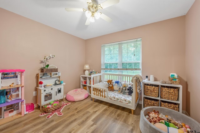 14677 County Road 2337, Tyler, TX 75707 - bedroom with wood finished floors, a nursery area, and a ceiling fan