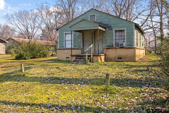 bungalow-style house featuring a front yard, crawl space, brick siding, and cooling unit