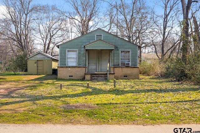 bungalow-style house with brick siding, crawl space, and a front yard