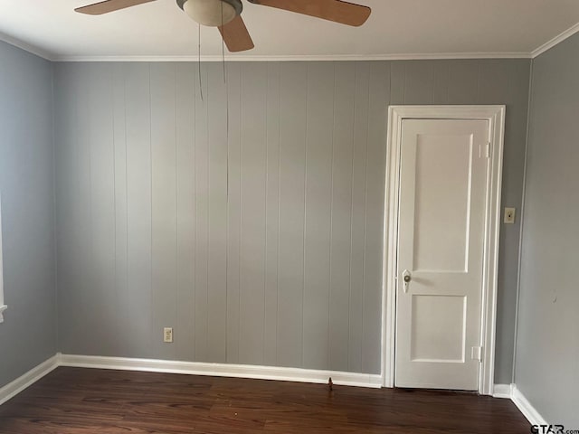 empty room with ornamental molding, dark hardwood / wood-style floors, and ceiling fan