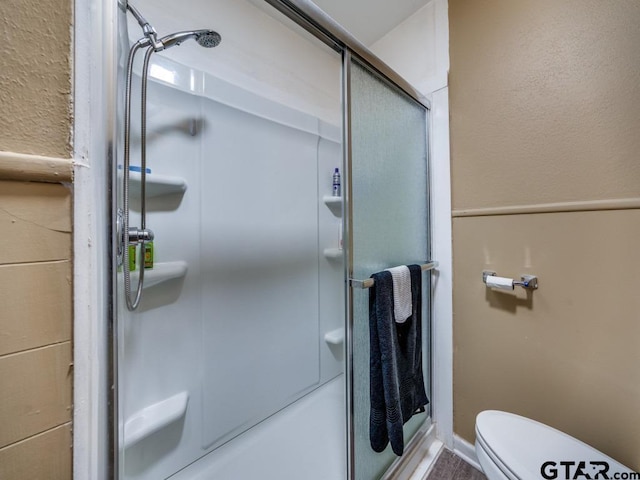 bathroom with toilet and an enclosed shower