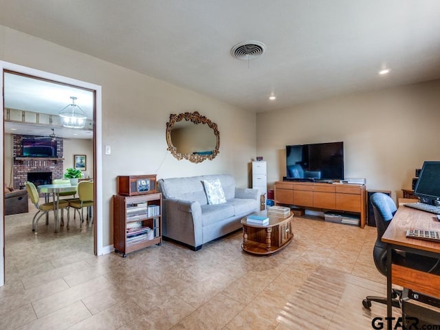 living room featuring a chandelier and a fireplace