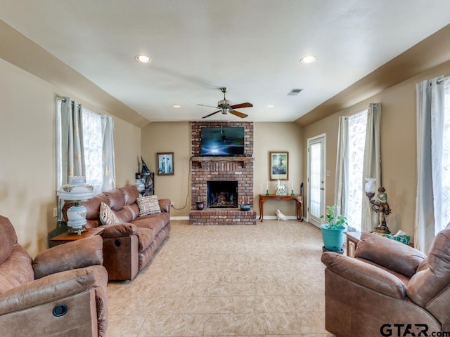 living room featuring a brick fireplace and ceiling fan