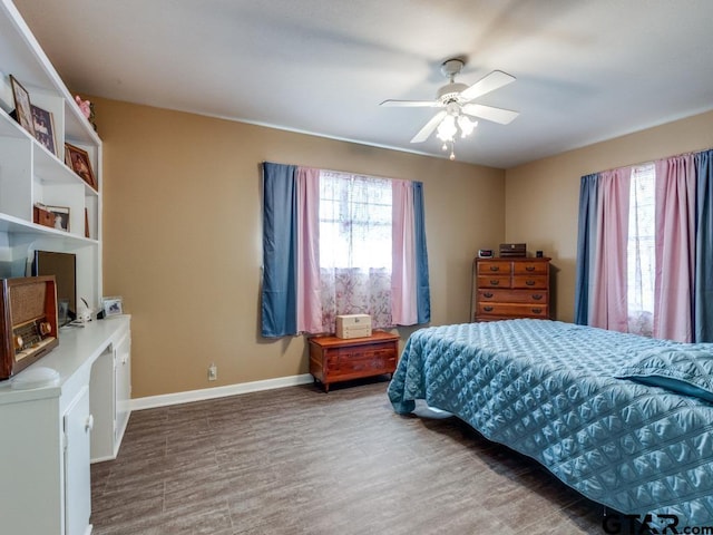 bedroom with multiple windows, hardwood / wood-style floors, and ceiling fan