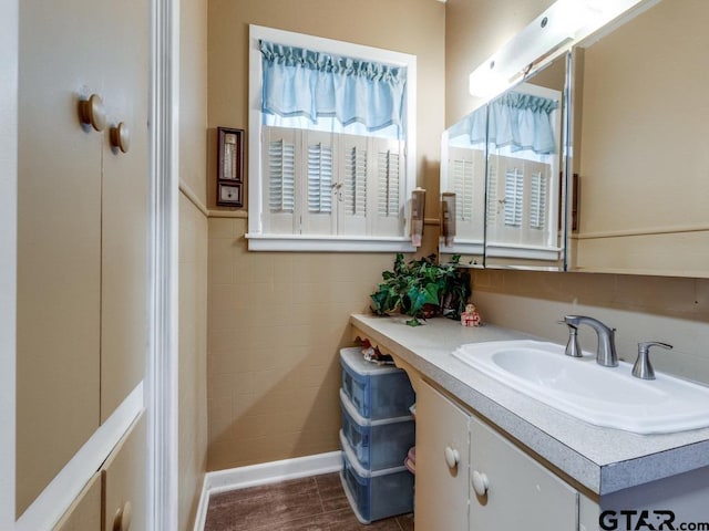 bathroom with hardwood / wood-style flooring, vanity, and tile walls