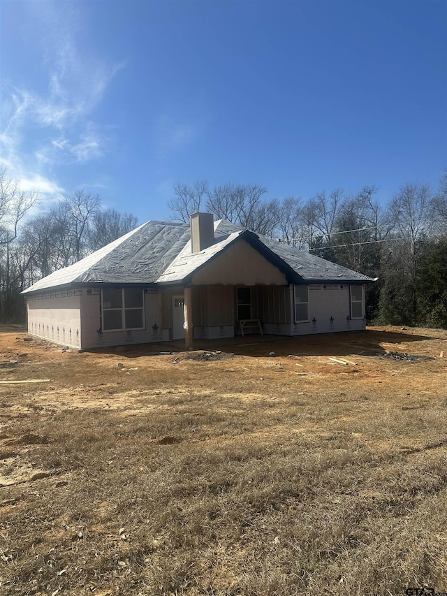 rear view of property with a lawn