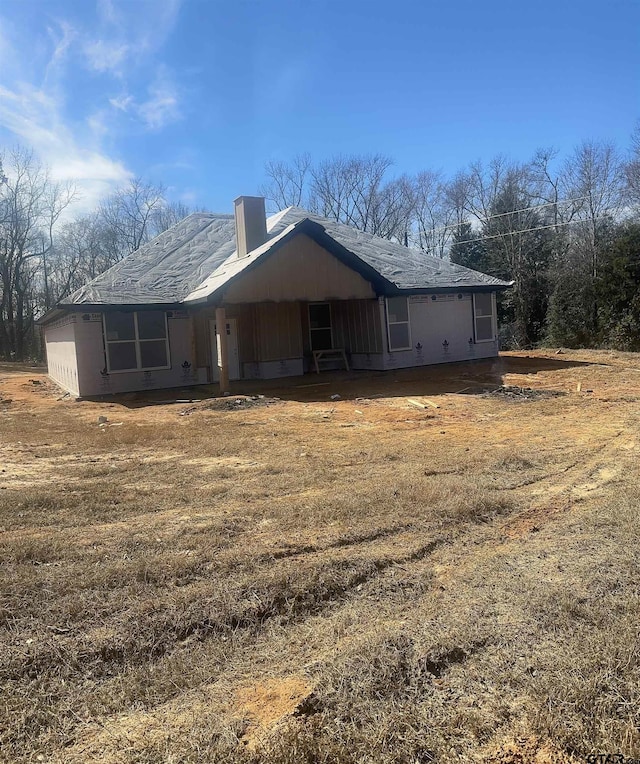 exterior space featuring a chimney and a front lawn