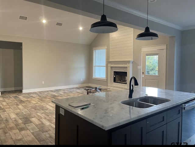 kitchen with open floor plan, visible vents, hanging light fixtures, and a sink