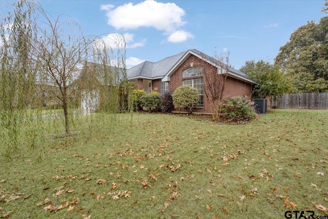 view of side of property featuring central AC and a lawn