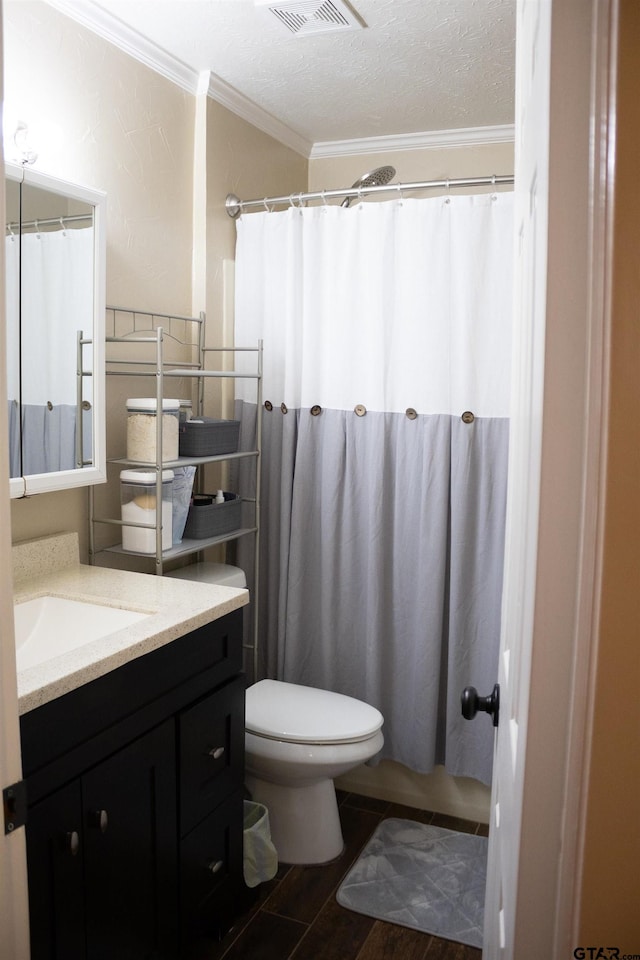 bathroom featuring toilet, hardwood / wood-style floors, a textured ceiling, ornamental molding, and vanity