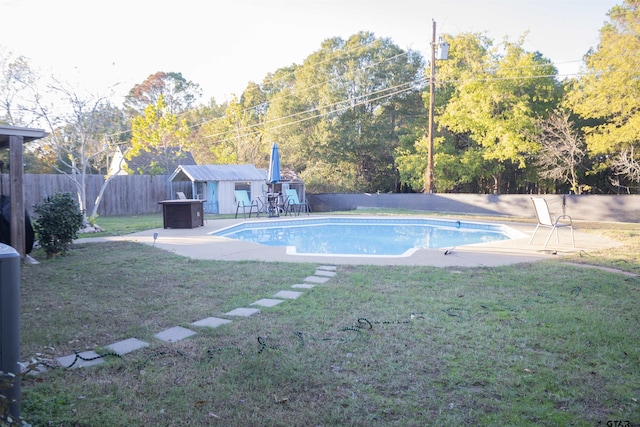 view of swimming pool featuring an outbuilding and a lawn