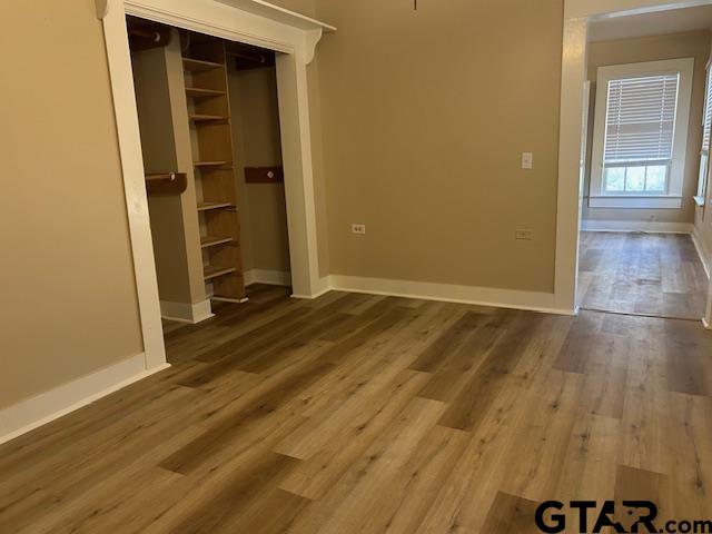 interior space with baseboards and wood finished floors
