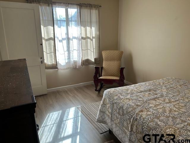 bedroom featuring baseboards and light wood-type flooring
