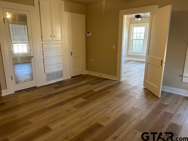 spare room with baseboards, ceiling fan, and wood finished floors