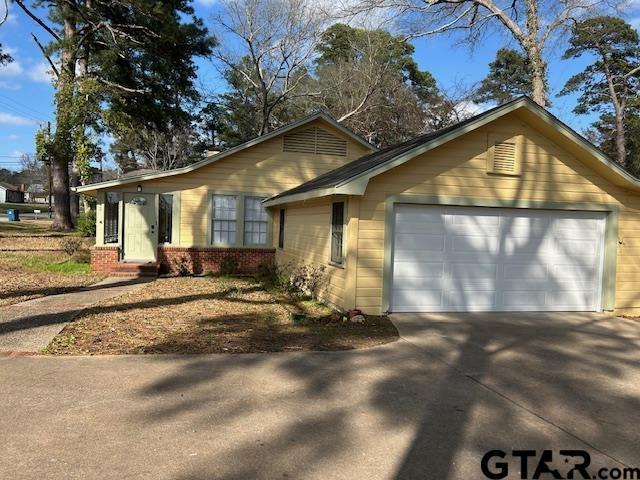 view of front of house with concrete driveway, brick siding, and a garage