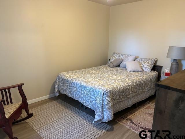 bedroom featuring baseboards and wood finished floors