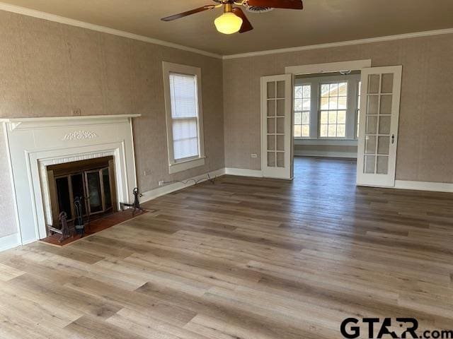 unfurnished living room featuring crown molding, ceiling fan, french doors, baseboards, and wood finished floors