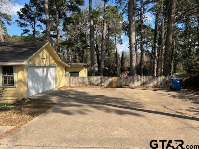 view of property exterior with fence and driveway