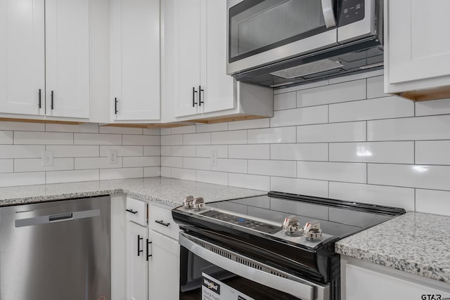 kitchen featuring tasteful backsplash, appliances with stainless steel finishes, and white cabinets