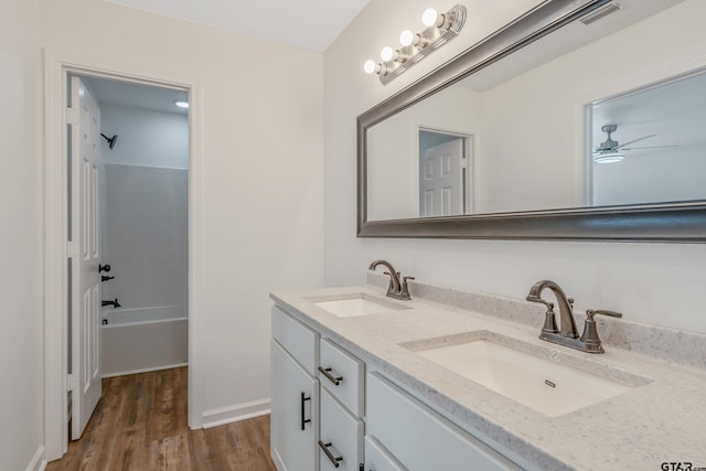 bathroom featuring ceiling fan, vanity, hardwood / wood-style floors, and shower / bathing tub combination