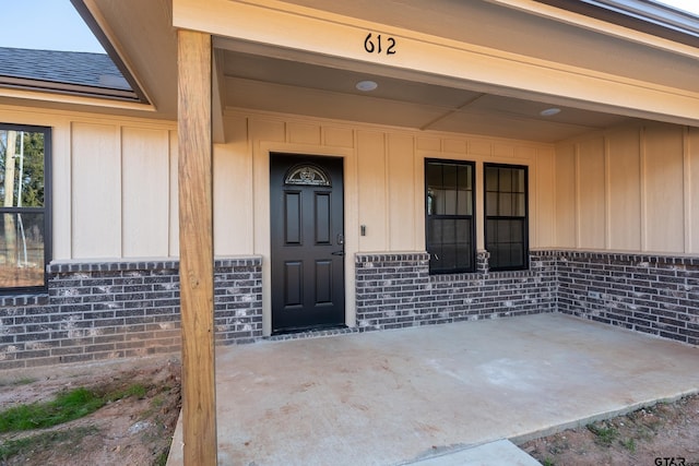 view of exterior entry with a patio