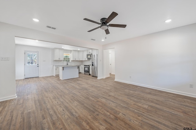 unfurnished living room featuring ceiling fan, sink, and light hardwood / wood-style flooring